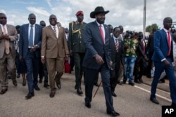 South Sudan's President Salva Kiir, center, arrives back in the country from peace talks in Addis Ababa, at the airport in Juba, South Sudan, June 22, 2018.