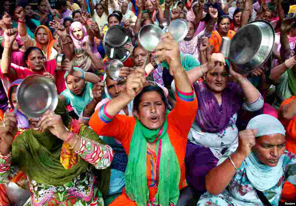 کارگران مهدکودک وسایل آشپزخانه را پرتاب می کنند و علیه پلیس شعار می دهند. این کارگران هندی به حقوق کم شان معترضند.