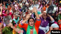 Kindergarten workers hit kitchenware and shout anti-government slogans during a protest demanding an increase in their monthly wages on the occasion of May Day in Chandigarh, India, May 1, 2016. 