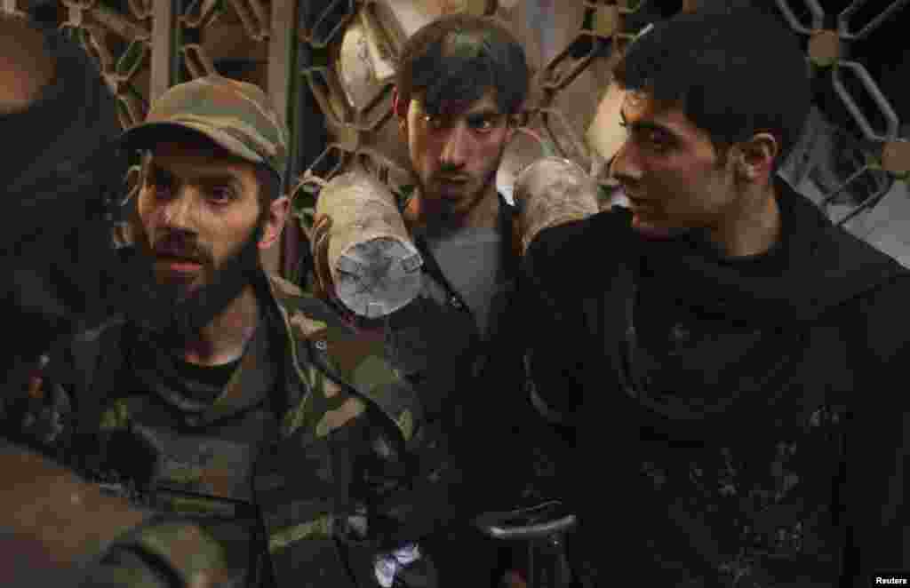 Free Syrian Army fighters talk to each other within the compound of the police headquarters near the Justice Palace in the old city of Aleppo, March 23, 2014.