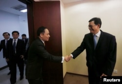 FILE - Chairman of Cambodia's border committee Var Kim Hong, right, shakes hands with Vietnamese Deputy Foreign Minister Le Hoai Trung before a meeting about the border between Cambodia and Vietnam in Phnom Penh, Aug. 29, 2016.