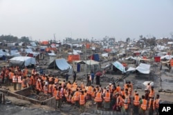 救援人员抵达位于孟加拉的一个罗兴亚人难民营帮助重建一场大火烧毁的营地。（2021年3月24日）