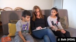 A volunteer at Refugee Connection Phoenix makes a weekly visit to a Syrian refugee family to help children learn English, in Phoenix, Arizona.