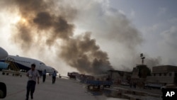 Smoke rises above the Jinnah International Airport where security forces continue to battle militants, June 9, 2014, in Karachi, Pakistan.