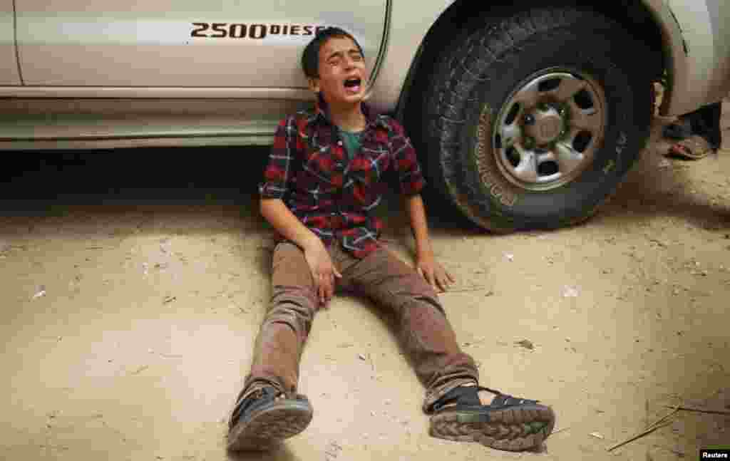 The son of one of the Palestinian members of Tayseer Al-Batsh&#39;s family, who hospital officials said were killed in an Israeli air strike, mourns during their funeral in Gaza City.