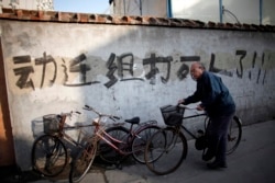 资料照：一名男子骑车走过上海街头一处拆迁地。（2010年12月1日）
