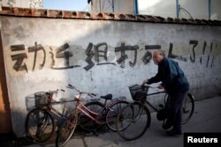 资料照：一名男子骑车走过上海街头一处拆迁地。（2010年12月1日）
