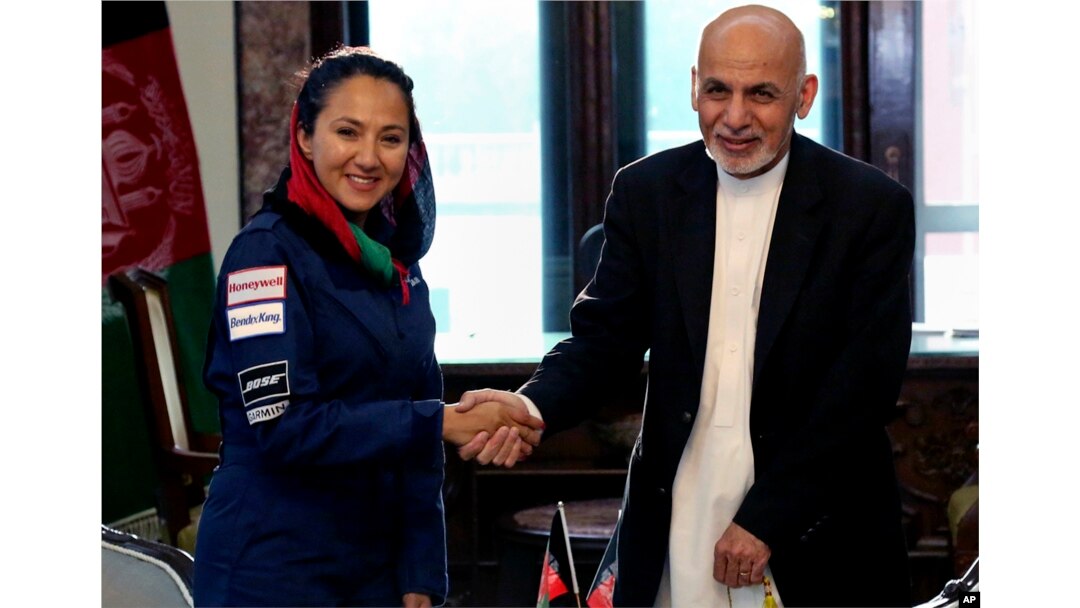 Presiden Afghanistan Ashraf Ghani berjabatan tangan dengan pilot AS keturunan Afghanistan Shaesta Waiz di Istana Presiden di Kabul, Afghanistan, 10 Juli 2017.