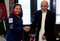 Presiden Afghanistan Ashraf Ghani berjabatan tangan dengan pilot AS keturunan Afghanistan Shaesta Waiz di Istana Presiden di Kabul, Afghanistan, 10 Juli 2017.