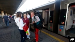 在乌克兰首都的火车站上，人们在即将开往波兰的列车旁边（2017年6月11日）