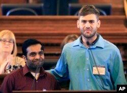 FILE - Alok Madasani (left) and Ian Grillot embrace after they were honored by the Kansas House of Representatives in Topeka, Kan. Adam Purinton was indicted by a federal grand jury, June 9, 2107, for a shooting in a suburban Kansas City bar. Srinivas Kuchibhotla was killed and his friend Alok Madasani was injured along with Ian Grillot, who intervened.