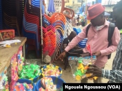 Franck Nzila Malembe, négociant les jouets au marché Poto Poto, au Congo-Brazzavile, le 22 décembre 2017. (VOA/Ngouela Ngoussou)