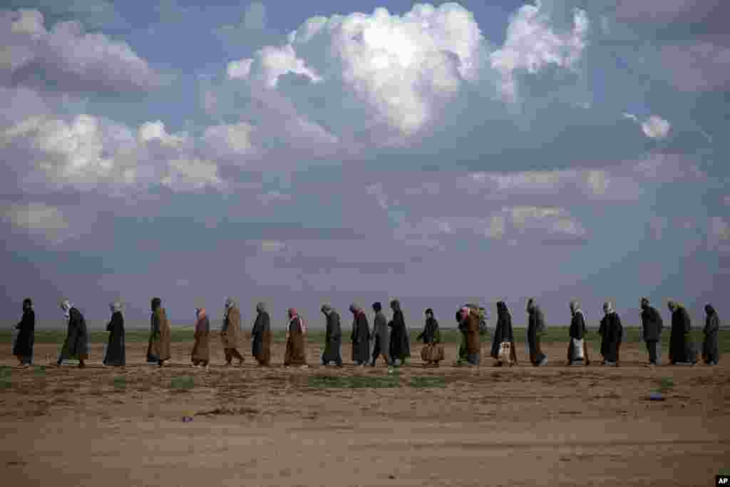 Men walk to be screened after being evacuated out of the last territory held by Islamic State militants, near Baghouz, eastern Syria.