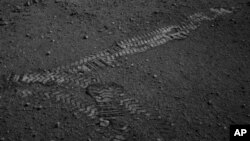 This NASA image shows the Curiosity rover's wheel tracks on the surface of Mars, from an image sent from one of the rover's cameras, August 22, 2012.