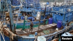 Police officers stand on a fishing boat during a police inspection at the pier of Songkhla, south Thailand, Dec. 23, 2015. Thailand said seafood exports to the United States, Europe and Australia have not been hit by reports of slavery and forced labor by campaign groups and media. 
