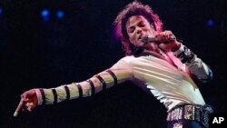 FILE - Michael Jackson leans, points and sings, dances and struts during the opening performance of his 13-city U.S. tour, in Kansas City, Mo. 