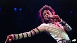 FILE - Michael Jackson leans, points and sings, dances and struts during the opening performance of his 13-city U.S. tour, in Kansas City, Mo. 