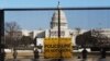 Penjaga nasional terlihat di pagar yang didirikan untuk memperkuat keamanan di sekitar Gedung Capitol, Washington. D.C., 13 Januari 2021 (Foto AP / Shafkat Anowar)