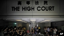 Newly elected Hong Kong lawmakers Yau Wai-ching (center left) and Sixtus Leung talk to journalists during a press conference outside the high court in Hong Kong, Nov. 15, 2016.