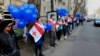 FILE - Supporters of the main opposition party wear Georgian national flags during a protest against buying gas from Russia's state-controlled Gazprom, in Tbilisi, Georgia, March 6, 2016. 