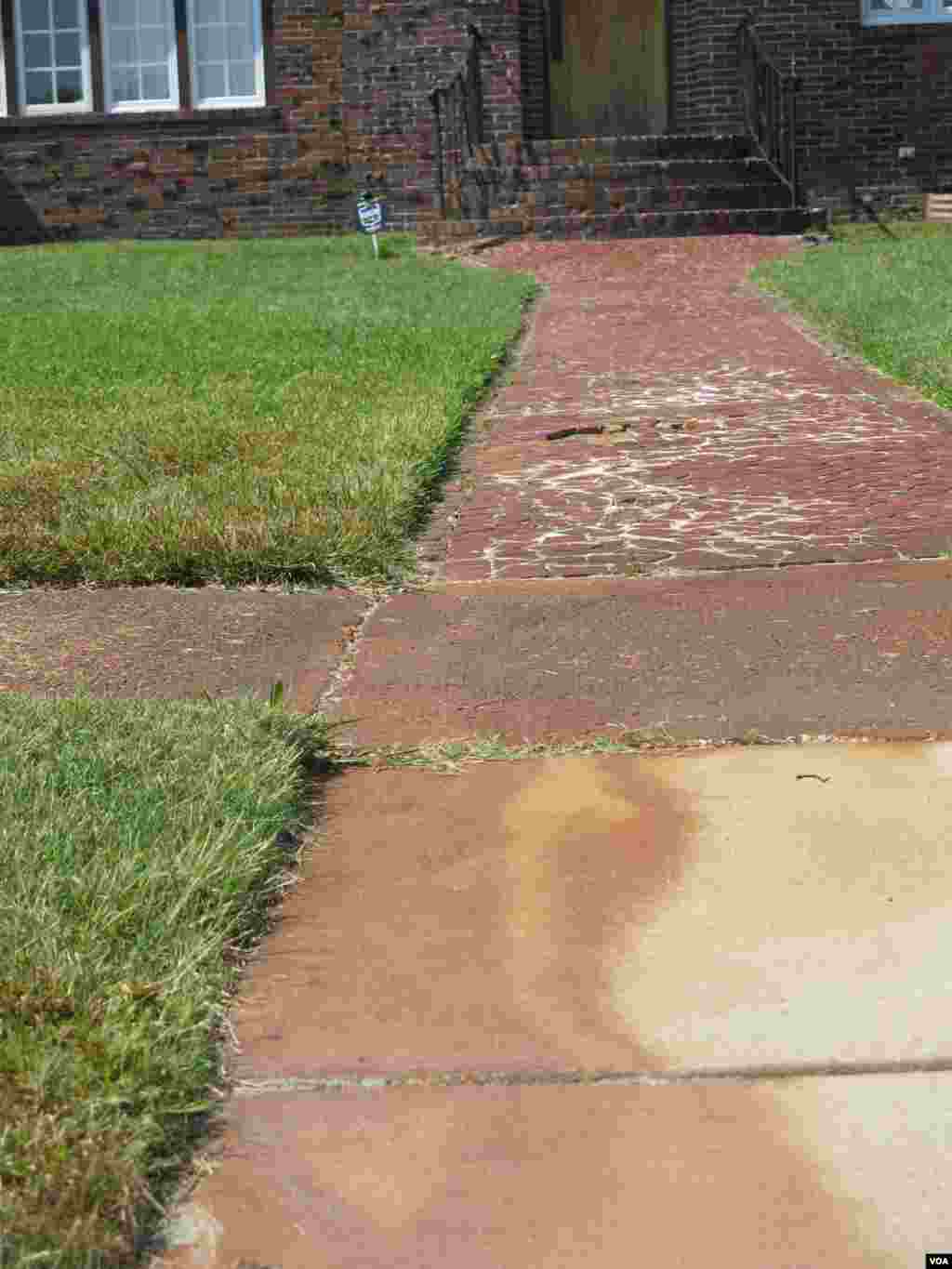 Even when flood water recedes tell-tale stains remain on the sidewalk. (Rosanne Skirble/VOA) 