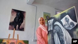 Somali artist Sana Ashraf Sharif Muhsin, 21, displays some of her paintings at her home in the capital Mogadishu, Somalia, Oct. 15, 2021. 