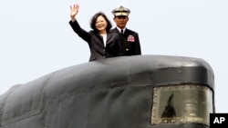 Taiwan's President Tsai Ing-wen, left, waves from a Zwaardvis-class submarine during a visit at Zuoying Naval base in Kaohsiung, southern Taiwan, Tuesday, March 21, 2017.