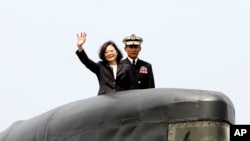 FILE - Taiwan's President Tsai Ing-wen, left, waves from a Zwaardvis-class submarine during a visit at Zuoying Naval base in Kaohsiung, southern Taiwan, March 21, 2017.