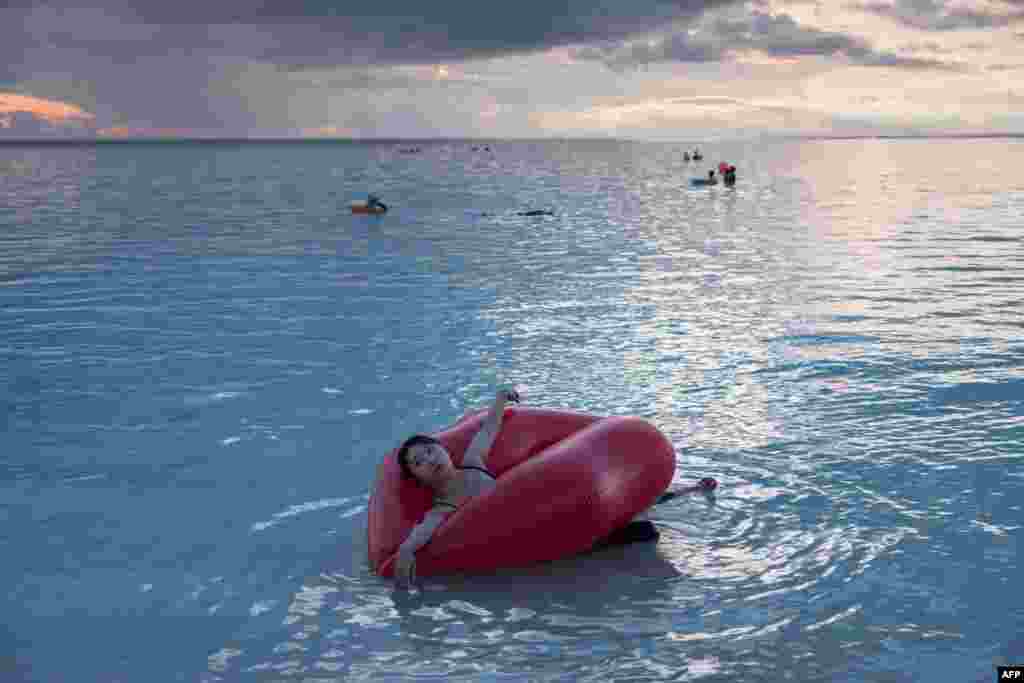 หญิงสาวเล่นน้ำในทะเลที่อ่าว Tumon bay ของเกาะกวมอย่างสบายอกสบายใจ หลังเกาหลีเหนือเลื่อนแผนโจมตีด้วยขีปนาวุธเมื่อต้นสัปดาห์ที่ผ่านมา