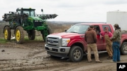 FILE - In this April 4, 2017, photo, Blake Hurst, a corn and soybean farmer and president of the Missouri Farm Bureau, talks with his son and his brothers on his farm in Missouri.