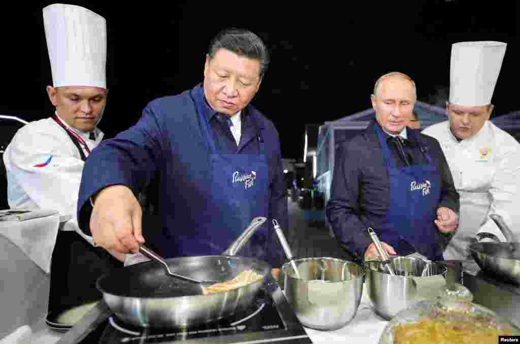 Presiden Rusia Vladimir Putin bersama tamunya, Presiden China Xi Jinping melakukan diplomasi "Pancake" dengan membuat kue pancake bersama-sama di sela acara Forum Ekonomi Timur di kota Vladivostok, Rusia Selasa (11/9).