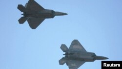 FILE - Two US F-22 fighter jets are seen in flight.
