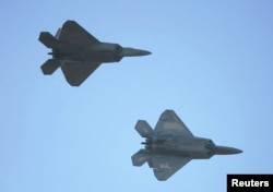 FILE - Two US F-22 fighter jets are seen in flight.