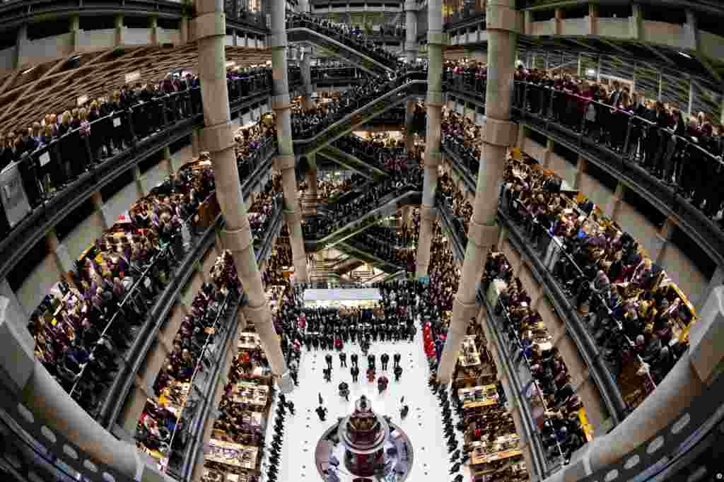 Brokers and underwriters line the balconies and escalators of the Lloyd's of London building in central London, during a two-minute silence observed in memory of Britain's war dead. The service at Lloyd's of London is observed with the ringing of the Lutine Bell and the laying of wreaths before the Book of Remembrance in addition to the two-minute silence.