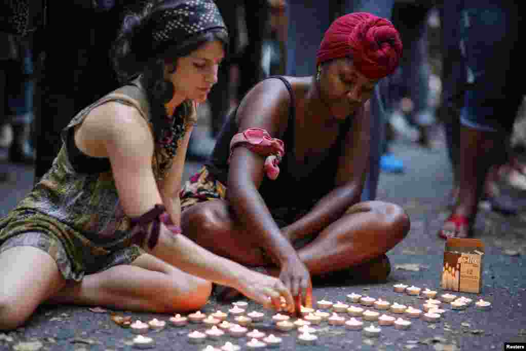 Women light candles while attending a vigil to honor Michael Brown, in Brooklyn, New York, Aug. 14, 2014.