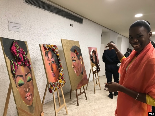 Tatou Dembele, a painter and owner of a food marketing company, points to her favorite of her own paintings. (E. Sarai/VOA)