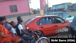 Un moto-taxi à côte d'un taxi à Bouaké, en Côte d'Ivoire, le 5 juin 2017. (VOA/Siriki Barro)