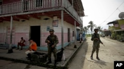 FILE - Panamanian border police patrol a street in Puerto Obaldia near the Colombian border in Panama, Sept. 16, 2015.