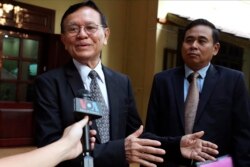 FILE - Cambodia's opposition leader Kem Sokha, left, talks to the media at his home before leaving for the court hearing in Phnom Penh, Thursday, Jan. 16, 2020.