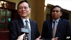 FILE PHOTO - Cambodia's opposition leader Kem Sokha, left, talks to the media at his home before leaving for the court hearing in Phnom Penh, Thursday, Jan. 16, 2020.