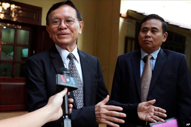 FILE - Cambodia's opposition leader Kem Sokha, left, talks to the media at his home before leaving for the court hearing in Phnom Penh, Thursday, Jan. 16, 2020.