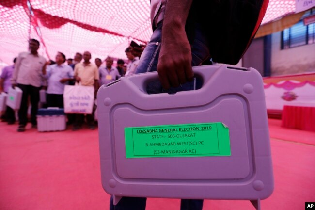 Officials on election duty carry electronic voting machines ahead of the general election in Ahmadabad, India, April 22, 2019.