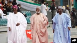 FILE- In this Sunday, May. 29, 2011 file photo Former Nigerian Presidents, Ernest Shonekon, left, Gen Abdulsalam Abubukar, centre, Gen Yakubu Gowon, third left arrived for the inauguration ceremony of former Nigeria President Goodluck Jonathan at the eagle square in Abuja, Nigeria. Former Nigerian rulers have banded together to sing a hymn for peace in their troubled nation, with some acknowledging they had a role in creating the "mess." Their video wish for 2017 is getting scornful comments from many on social media.