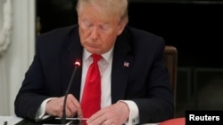 In this file photo, U.S. President Donald Trump is seen tapping the screen on a mobile phone at the White House in Washington, U.S., June 18, 2020. (REUTERS/Leah Millis)