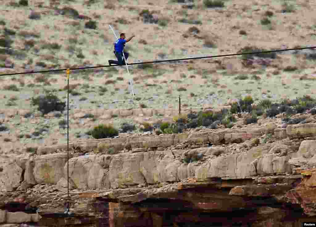 Daredevil Nik Wallenda gives a thumbs-up sign as he nears the end of his treacherous walk across a remote gorge near the Grand Canyon.