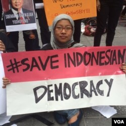 A traditional Indonesian Muslim sees the latest reforms as a step backward for her country, at a protest in New York, Sept. 29, 2014. (VOA / A. Phillips)