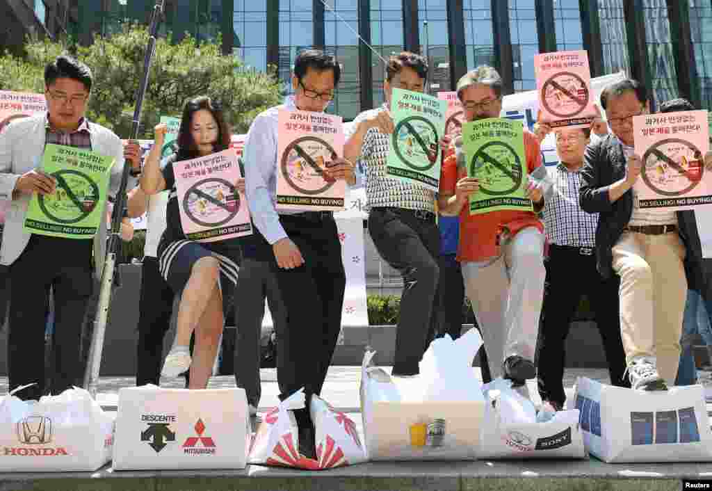 South Korean merchants step on boxes bearing logos of Japanese products during a rally to declare a boycott of Japanese goods in Seoul, South Korea, July 5, 2019.