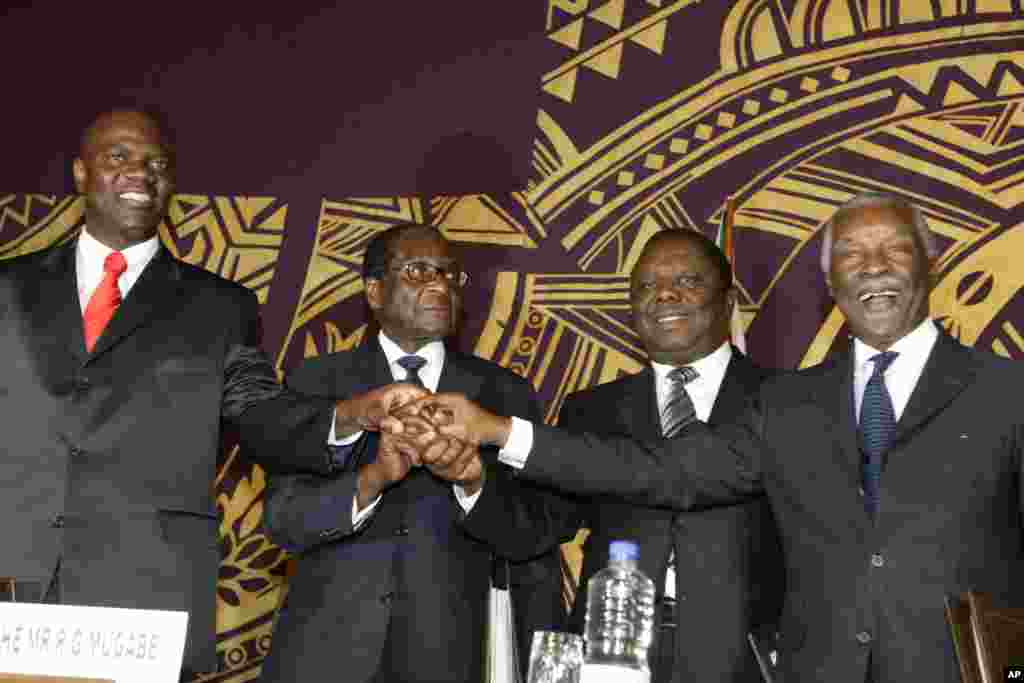 Officials join hands at the signing of the power-sharing deal in Harare, Zimbabwe, Sept, 15, 2008. From left: Arthur Mutmbara, deputy prime minster; Robert Mugabe, president; Morgan Tsvangirai, prime minster; and Thabo Mbeki, South Africa&#39;s president.