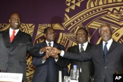 FILE - Officials join hands at the signing of the power-sharing deal in Harare, Zimbabwe, Sept, 15, 2008. From left: Arthur Mutmbara, deputy prime minster; Robert Mugabe, president; Morgan Tsvangirai, prime minster; and Thabo Mbeki, South Africa's president.
