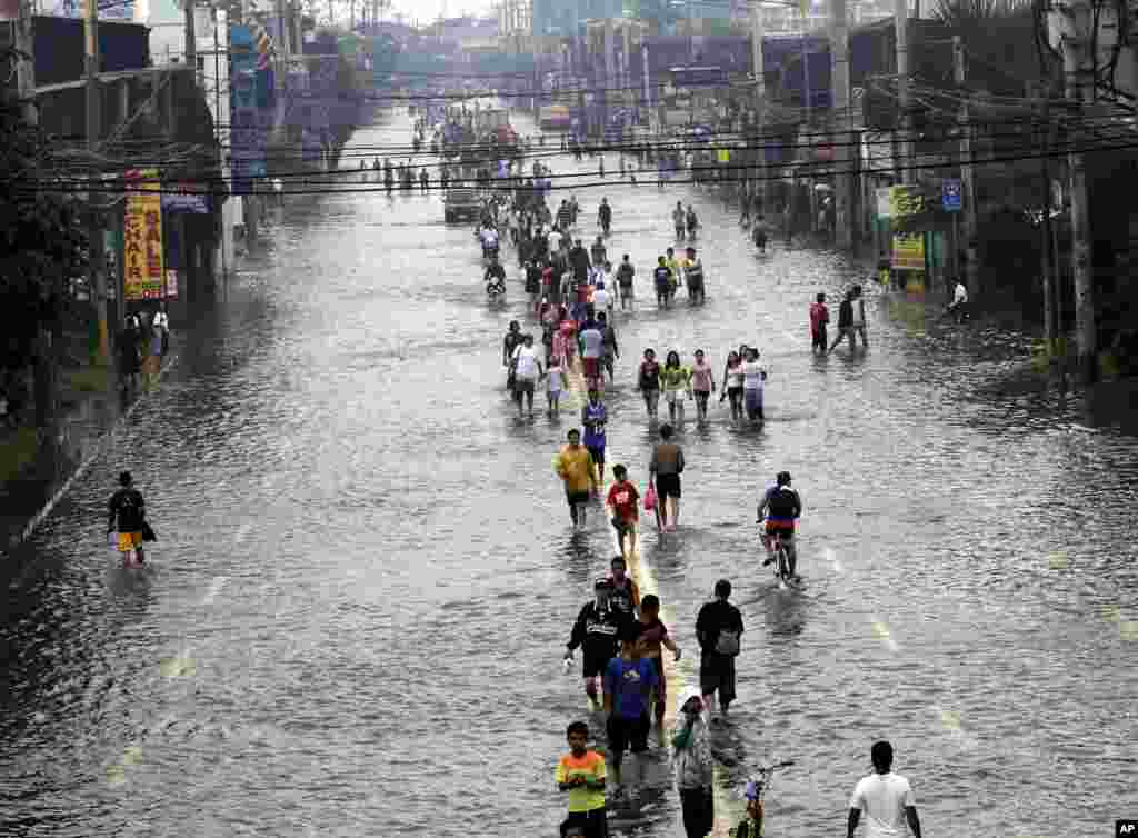 Người d&acirc;n đi lại tr&ecirc;n con đường ngập nước ở ngoại &ocirc; th&agrave;nh phố Pasig, ph&iacute;a đ&ocirc;ng Manila, 9 th&aacute;ng 8, 2012.